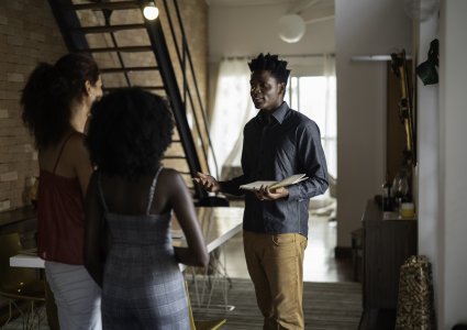 Two women touring homes with a real estate agent