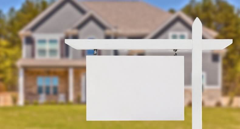 blank real estate sign in front of house | SIGNATURE PROPERTIES GROUP
