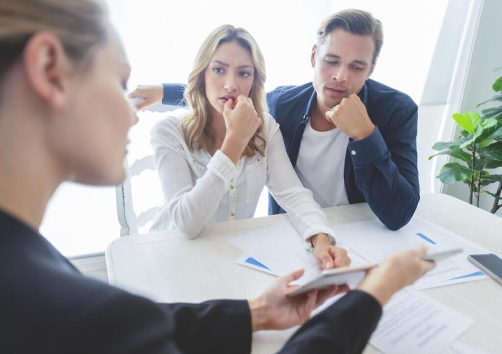 couple with real estate agent contemplating whether to buy a condo or buy a house